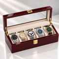 Coffret ouvert, cinq montres en ligne sous la vitre