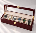 Coffret ouvert, six montres alignées sous la vitre