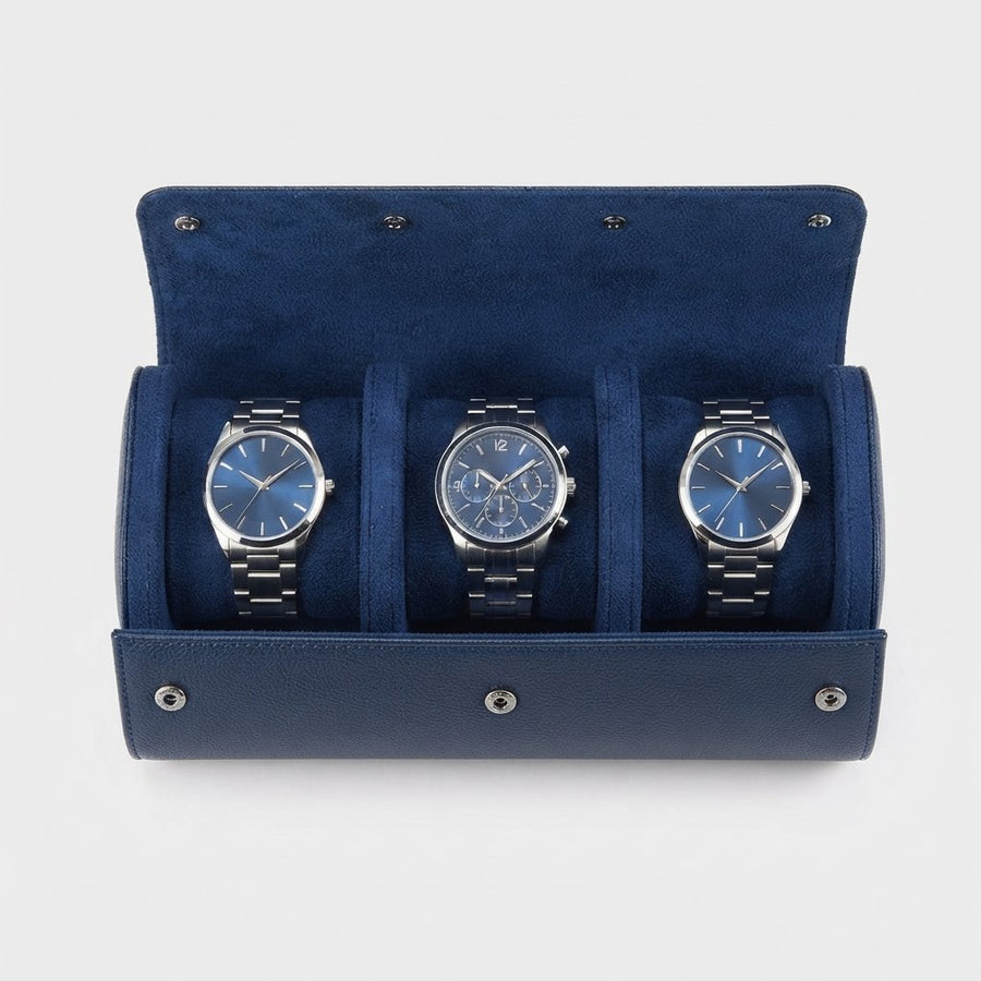 Étui ouvert vu de dessus, trois montres côte à côte dans leurs berceaux en suédine bleu marine.