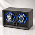 Caisson gris fumé vu de face, deux molettes, une montre chronographe et une montre à cadran bleu dans leurs anneaux bleus