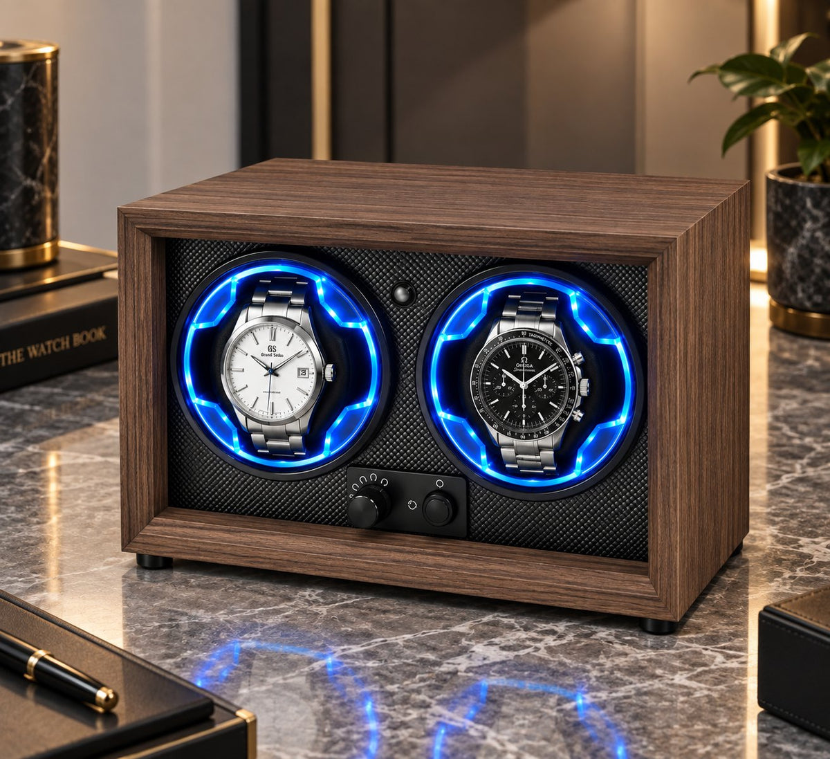 Vu de trois quarts sur une table de nuit en marbre, deux montres claire et sombre dans leurs anneaux bleus